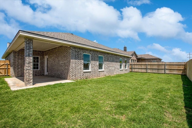 rear view of property featuring a lawn and a patio area