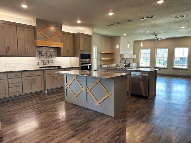 kitchen featuring sink, dark hardwood / wood-style flooring, a kitchen island, pendant lighting, and stainless steel appliances