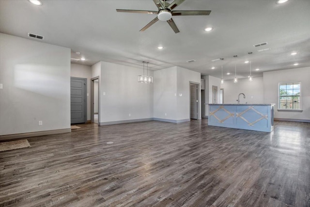 unfurnished living room with sink, dark wood-type flooring, and ceiling fan