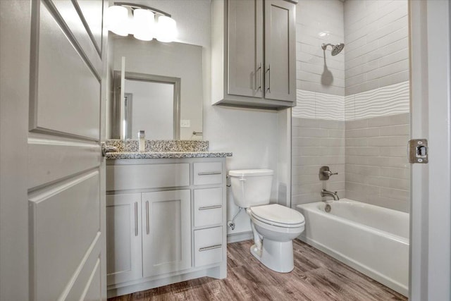 full bathroom featuring vanity, toilet, tiled shower / bath combo, and hardwood / wood-style floors