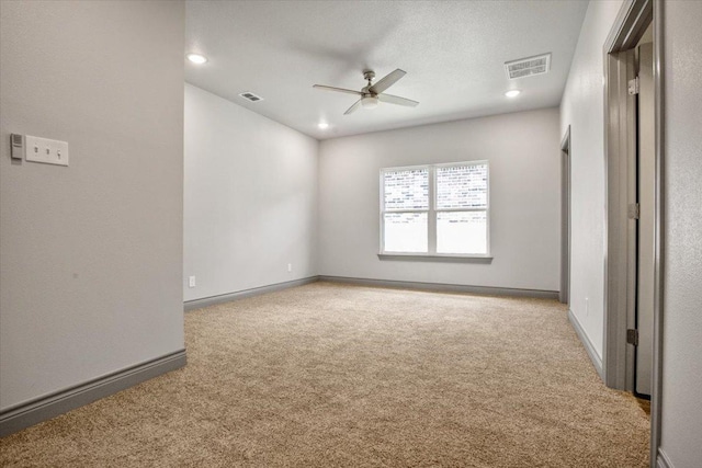 spare room featuring ceiling fan and light carpet