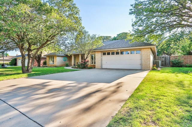 view of front of property with central AC unit, a garage, and a front lawn