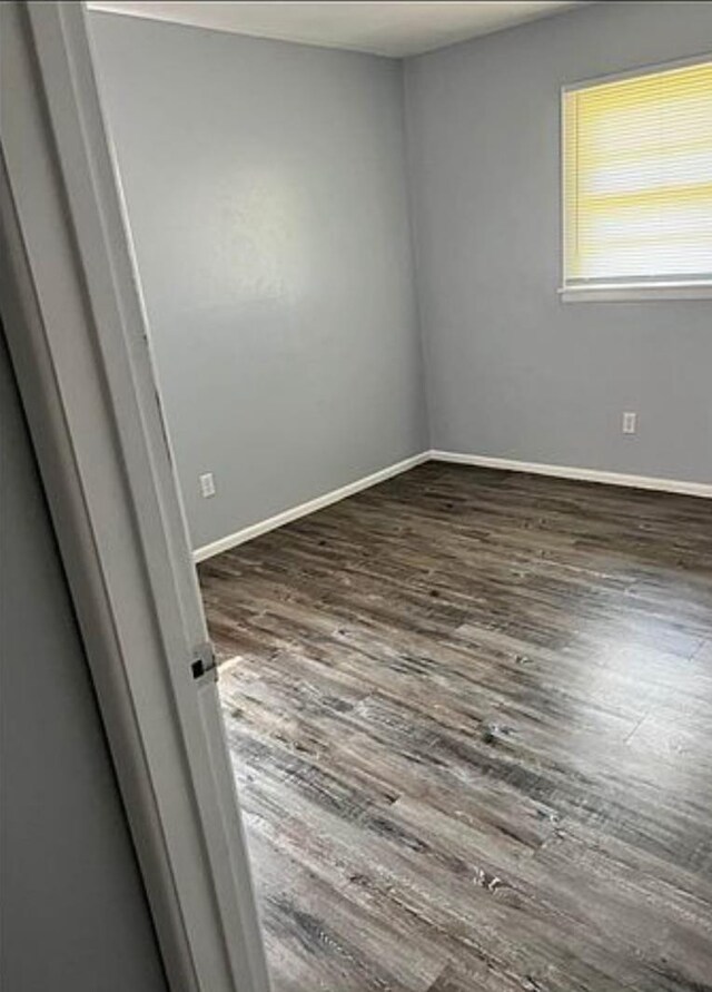 empty room with dark hardwood / wood-style flooring