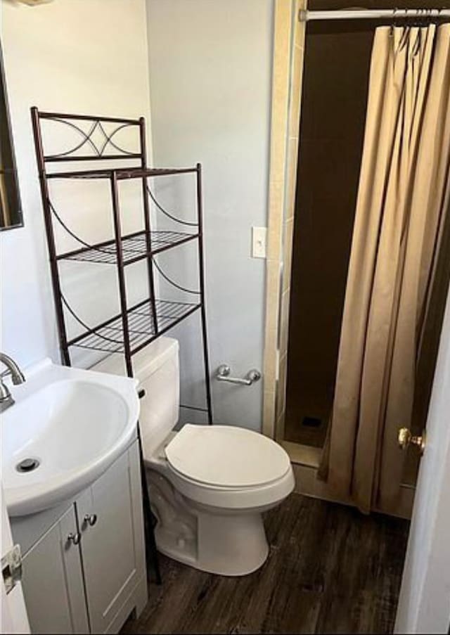 bathroom with a shower with curtain, vanity, toilet, and hardwood / wood-style floors