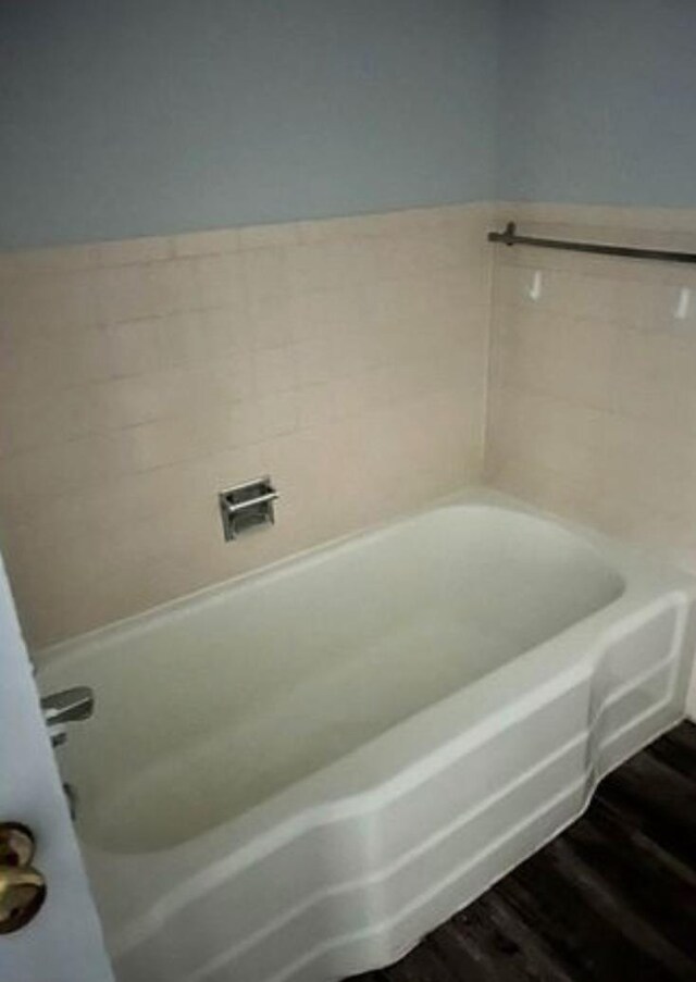 bathroom with wood-type flooring and a washtub