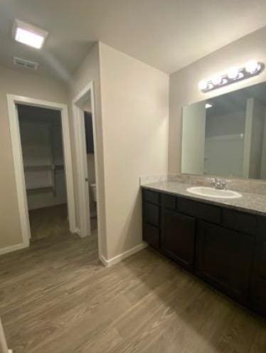 bathroom featuring wood-type flooring, vanity, and toilet