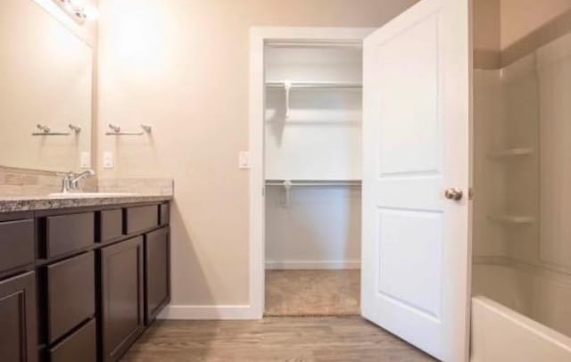 bathroom with shower / tub combination, wood-type flooring, and vanity