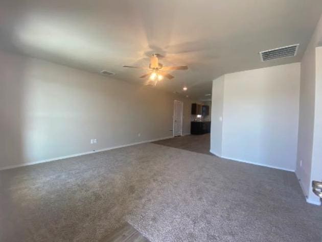 empty room featuring dark carpet and ceiling fan