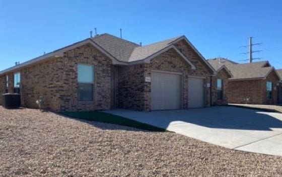 ranch-style home featuring central AC and a garage