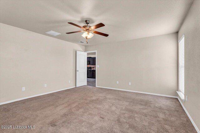 7024 34th Pl, Lubbock, TX 79407 - empty room featuring a ceiling fan, carpet floors, and baseboards