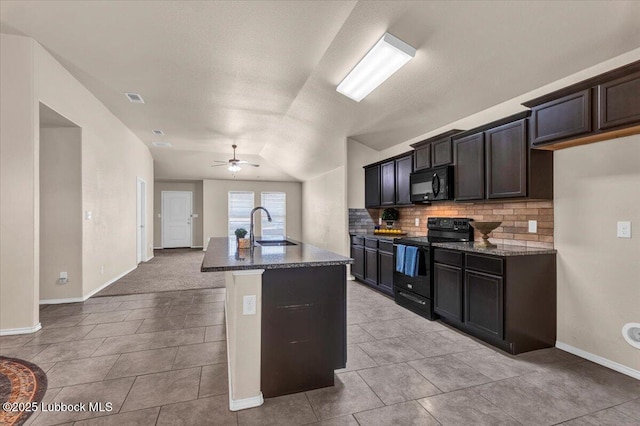 7024 34th Pl, Lubbock, TX 79407 - kitchen with black appliances, decorative backsplash, dark stone countertops, a sink, and lofted ceiling