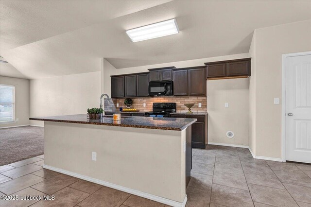 7024 34th Pl, Lubbock, TX 79407 - kitchen with black appliances, a sink, backsplash, a center island with sink, and light tile patterned floors