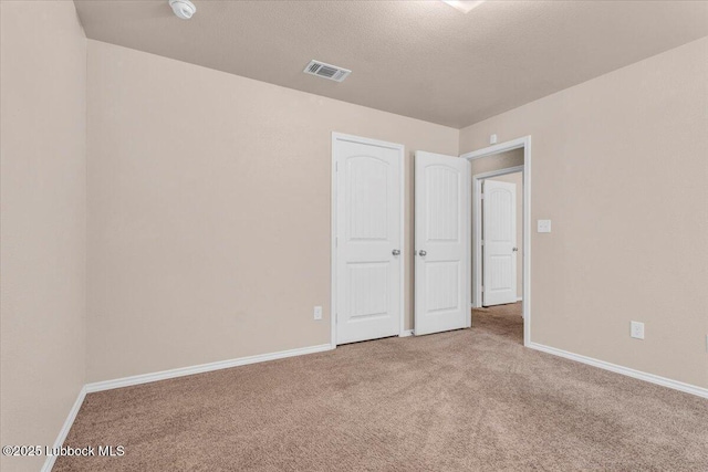 7024 34th Pl, Lubbock, TX 79407 - unfurnished bedroom featuring carpet, baseboards, and a textured ceiling
