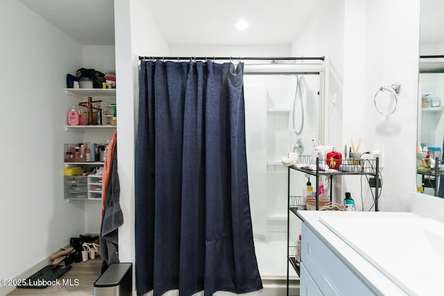 7415 8th St, Lubbock, TX 79416 - full bath featuring vanity, a stall shower, and wood finished floors