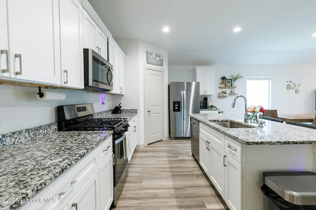 7415 8th St, Lubbock, TX 79416 - kitchen with appliances with stainless steel finishes, a sink, white cabinetry, light wood-type flooring, and recessed lighting