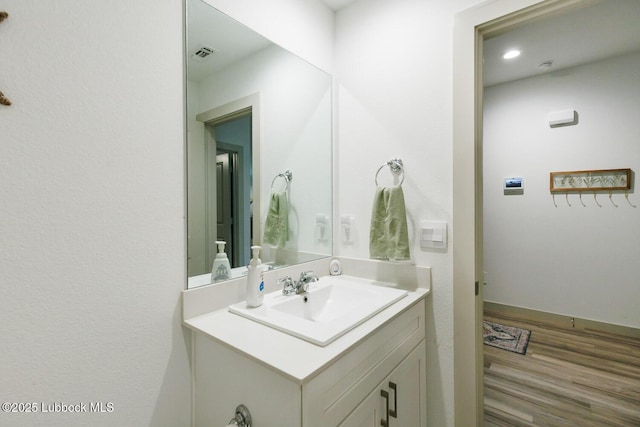 7415 8th St, Lubbock, TX 79416 - bathroom with vanity, wood finished floors, and baseboards