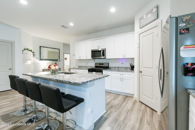 7415 8th St, Lubbock, TX 79416 - kitchen with appliances with stainless steel finishes, a sink, light wood-type flooring, light stone counters, and recessed lighting