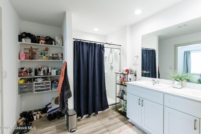 7415 8th St, Lubbock, TX 79416 - full bath featuring a shower stall, wood finished floors, double vanity, and recessed lighting
