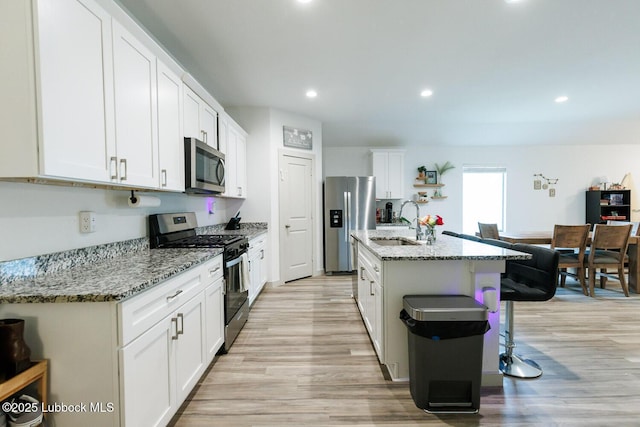 7415 8th St, Lubbock, TX 79416 - kitchen featuring stainless steel appliances, a sink, light wood finished floors, white cabinets, and recessed lighting