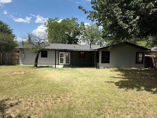 rear view of property with a lawn and french doors