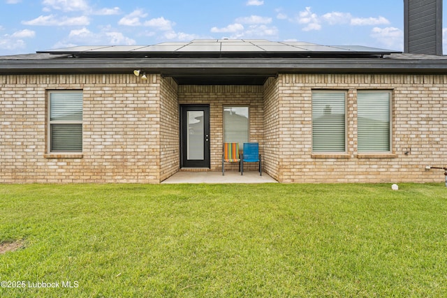 5303 Lehigh St, Lubbock, TX 79416 - back of house featuring brick siding, solar panels, a patio, a lawn, and a chimney