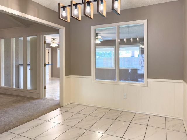 carpeted empty room with ceiling fan and a textured ceiling