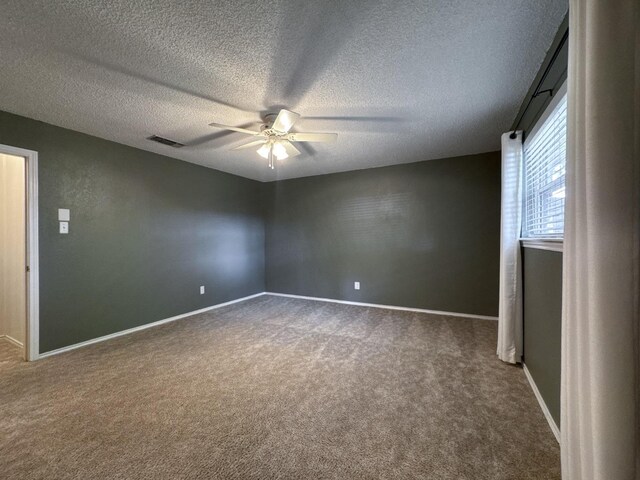 spare room with a textured ceiling, carpet floors, and ceiling fan