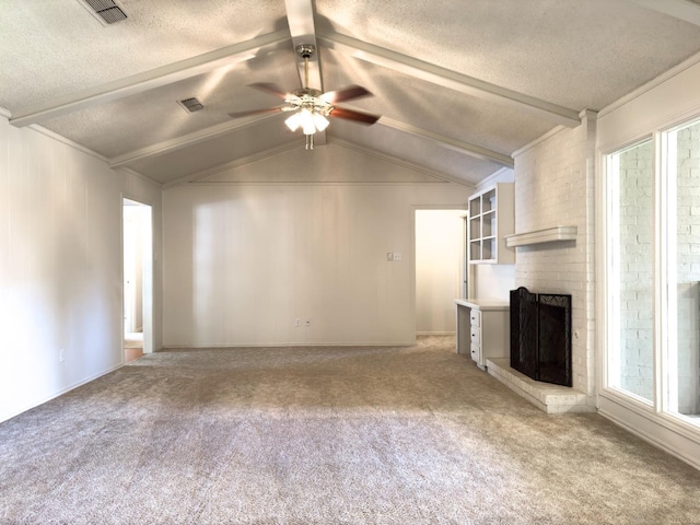 unfurnished living room featuring lofted ceiling with beams, carpet floors, a brick fireplace, and a textured ceiling