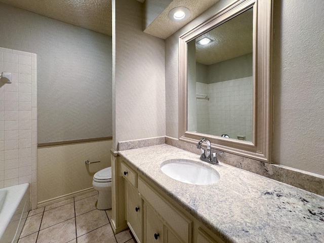 bathroom featuring tile patterned flooring, vanity, a textured ceiling, and toilet