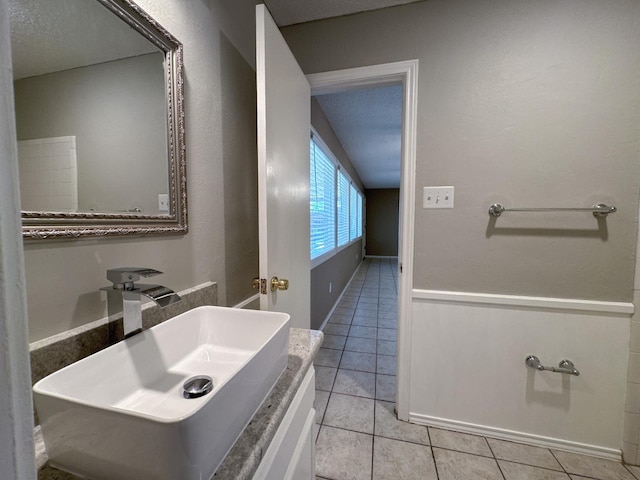 bathroom featuring tile patterned flooring, vanity, and a textured ceiling