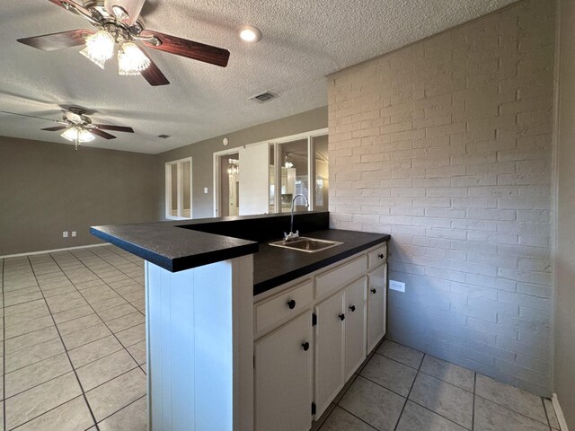 kitchen featuring white cabinetry, sink, light tile patterned flooring, and kitchen peninsula