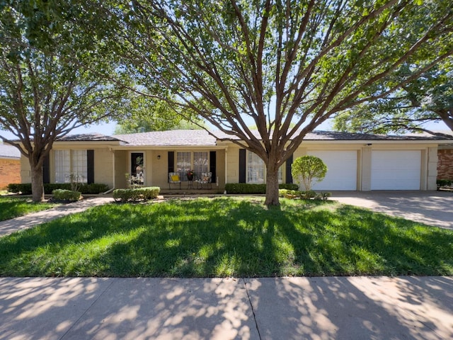 single story home featuring a garage and a front yard