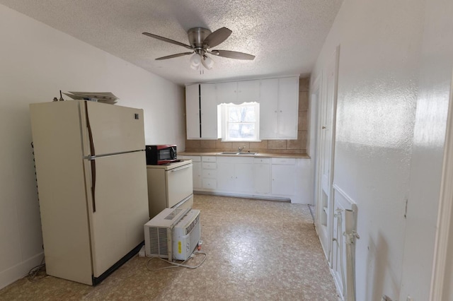 kitchen with sink, white cabinets, white appliances, ceiling fan, and a textured ceiling