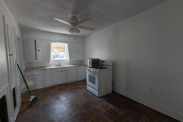 kitchen with white gas range, a textured ceiling, white cabinets, and ceiling fan