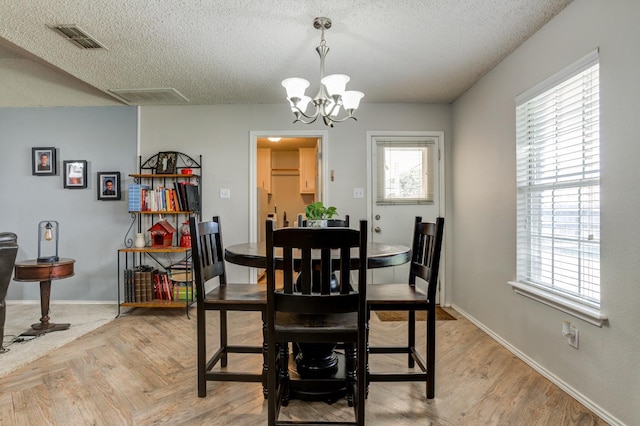 dining space featuring a chandelier, a textured ceiling, and a wealth of natural light