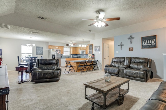 living room featuring plenty of natural light, light carpet, and a textured ceiling