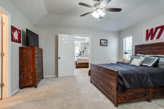 carpeted bedroom with a textured ceiling, vaulted ceiling, and ceiling fan