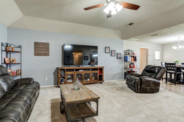 living room with carpet, ceiling fan with notable chandelier, and a textured ceiling