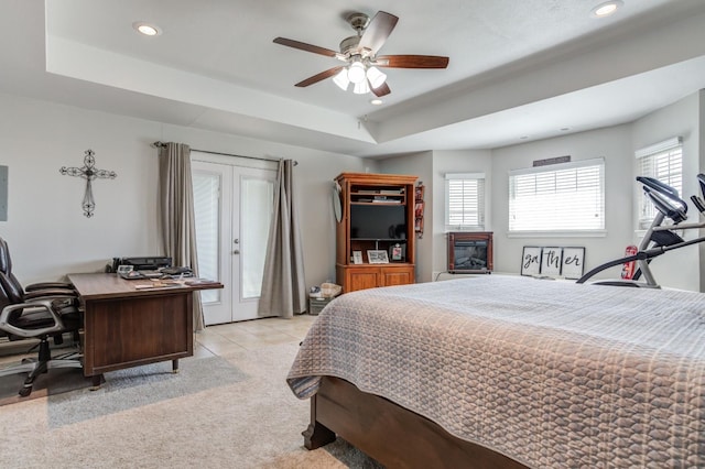 carpeted bedroom with a tray ceiling and ceiling fan