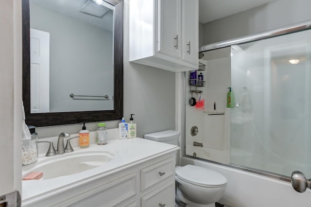 full bathroom with bath / shower combo with glass door, vanity, and toilet