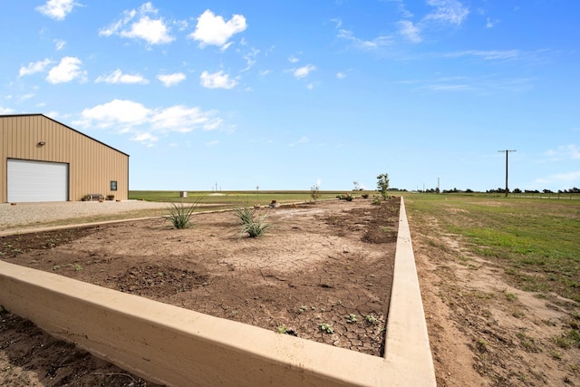 view of yard featuring a rural view and a garage