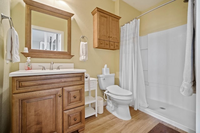 bathroom with a shower with curtain, vanity, hardwood / wood-style flooring, and toilet