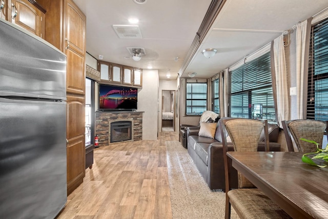 living room with a stone fireplace and light hardwood / wood-style floors