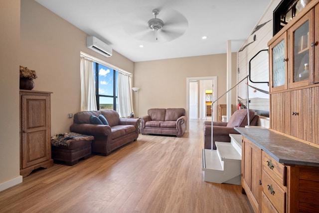 living room with ceiling fan, a wall mounted AC, and light wood-type flooring