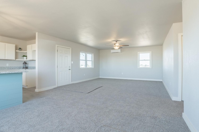 carpeted empty room featuring a wealth of natural light and ceiling fan