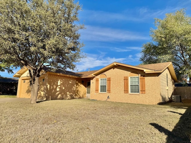 ranch-style home with a front lawn and central air condition unit