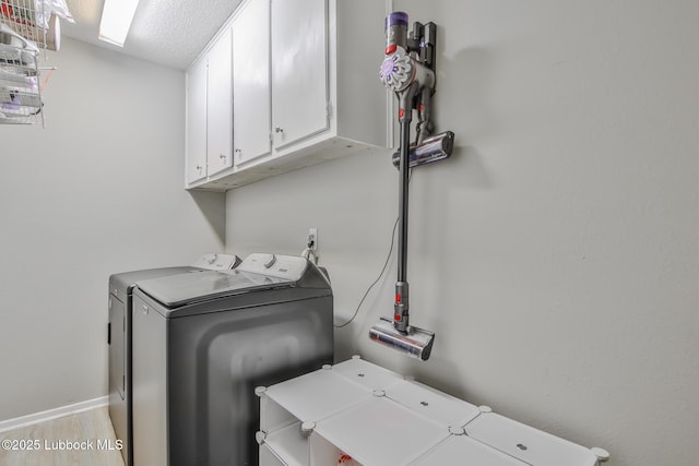 4816 55th St, Lubbock, TX 79414 - laundry area with cabinet space, washer and dryer, baseboards, a textured ceiling, and wood finished floors