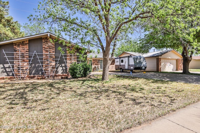4816 55th St, Lubbock, TX 79414 - view of grassy yard with an outbuilding, an attached garage, and driveway