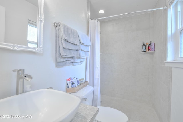 4816 55th St, Lubbock, TX 79414 - bathroom with a sink, tiled shower, and toilet