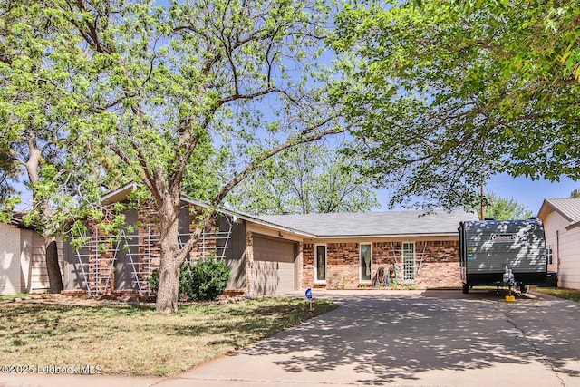 4816 55th St, Lubbock, TX 79414 - view of front facade featuring concrete driveway, an attached garage, and brick siding